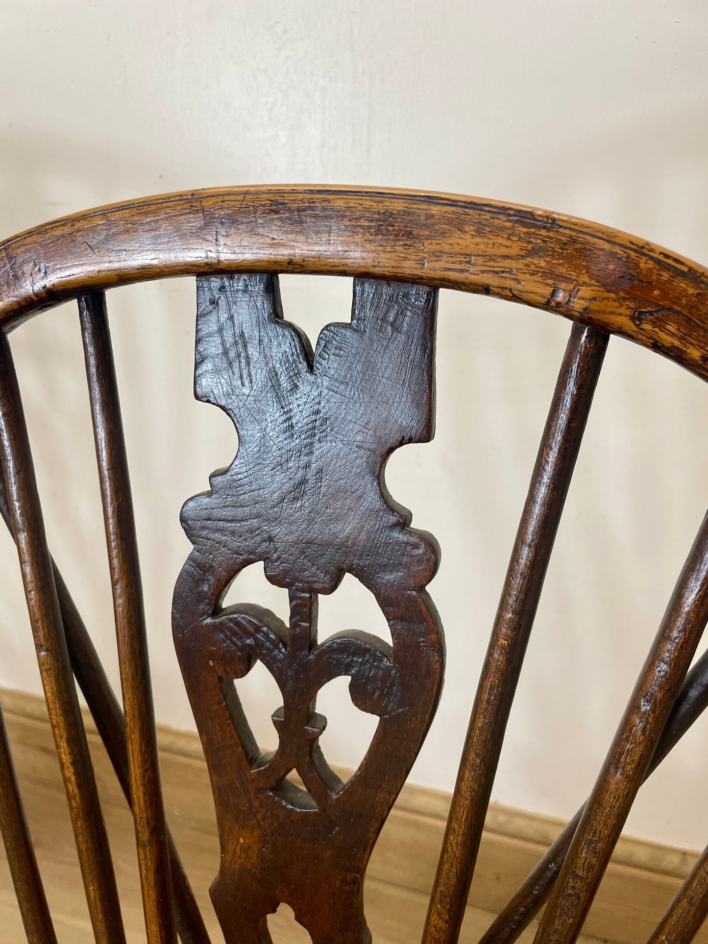 Close-up of a wooden chair with intricate carvings on a plain background