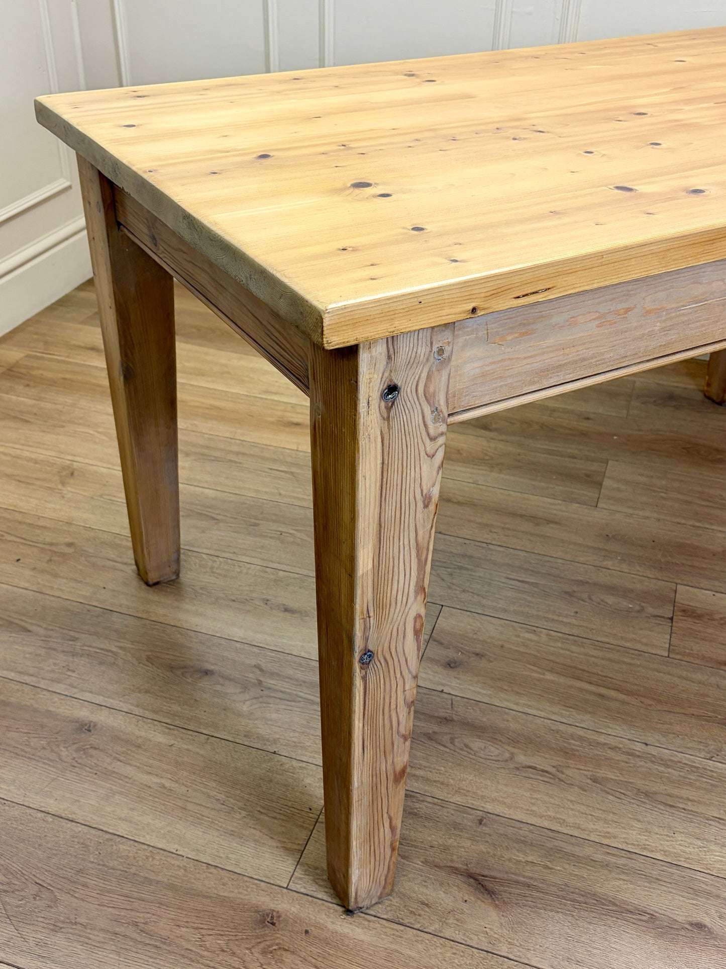 Wooden table on a wooden floor with a white wall background