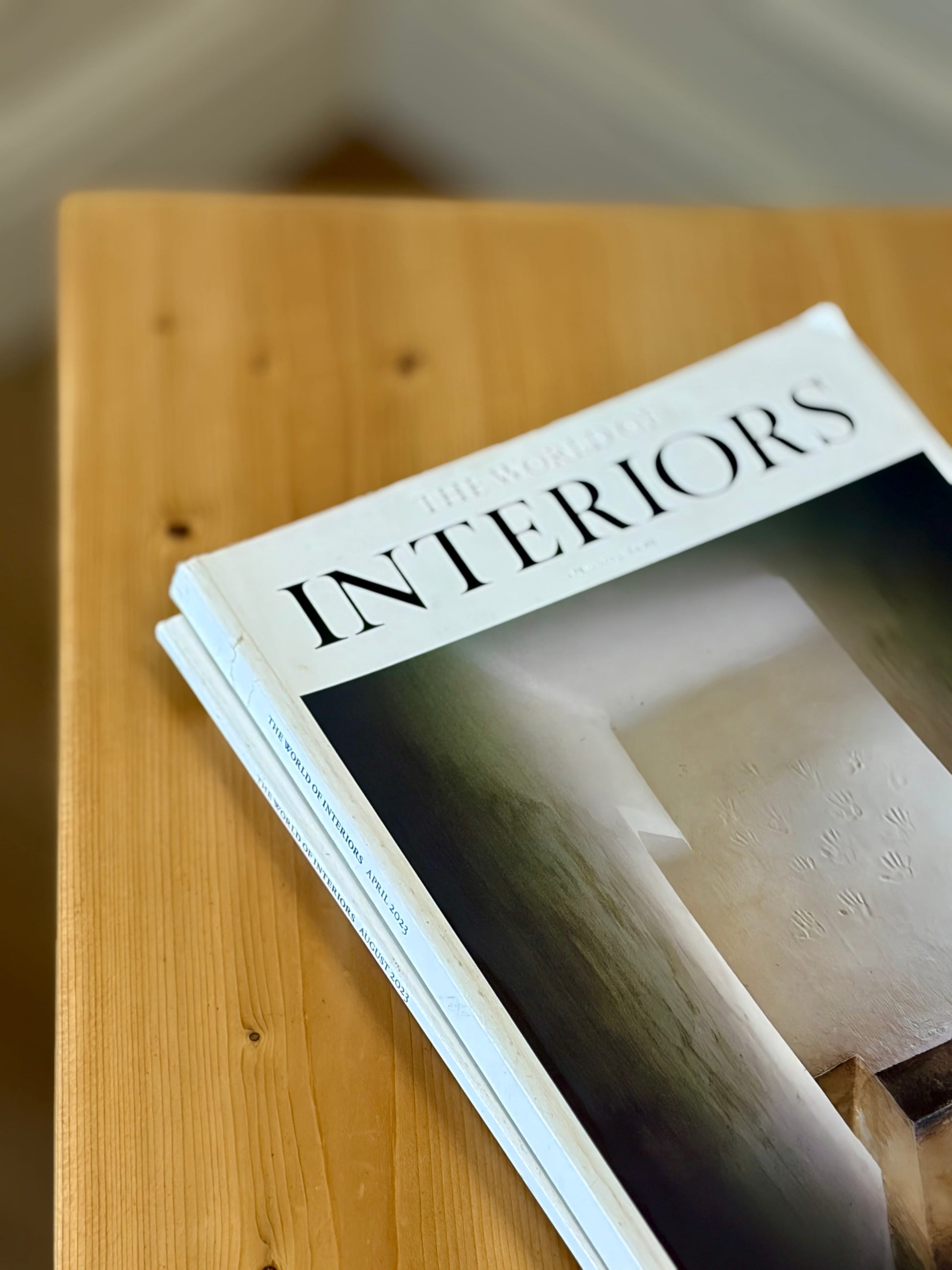 Stack of 'Interiors' magazines on a wooden surface