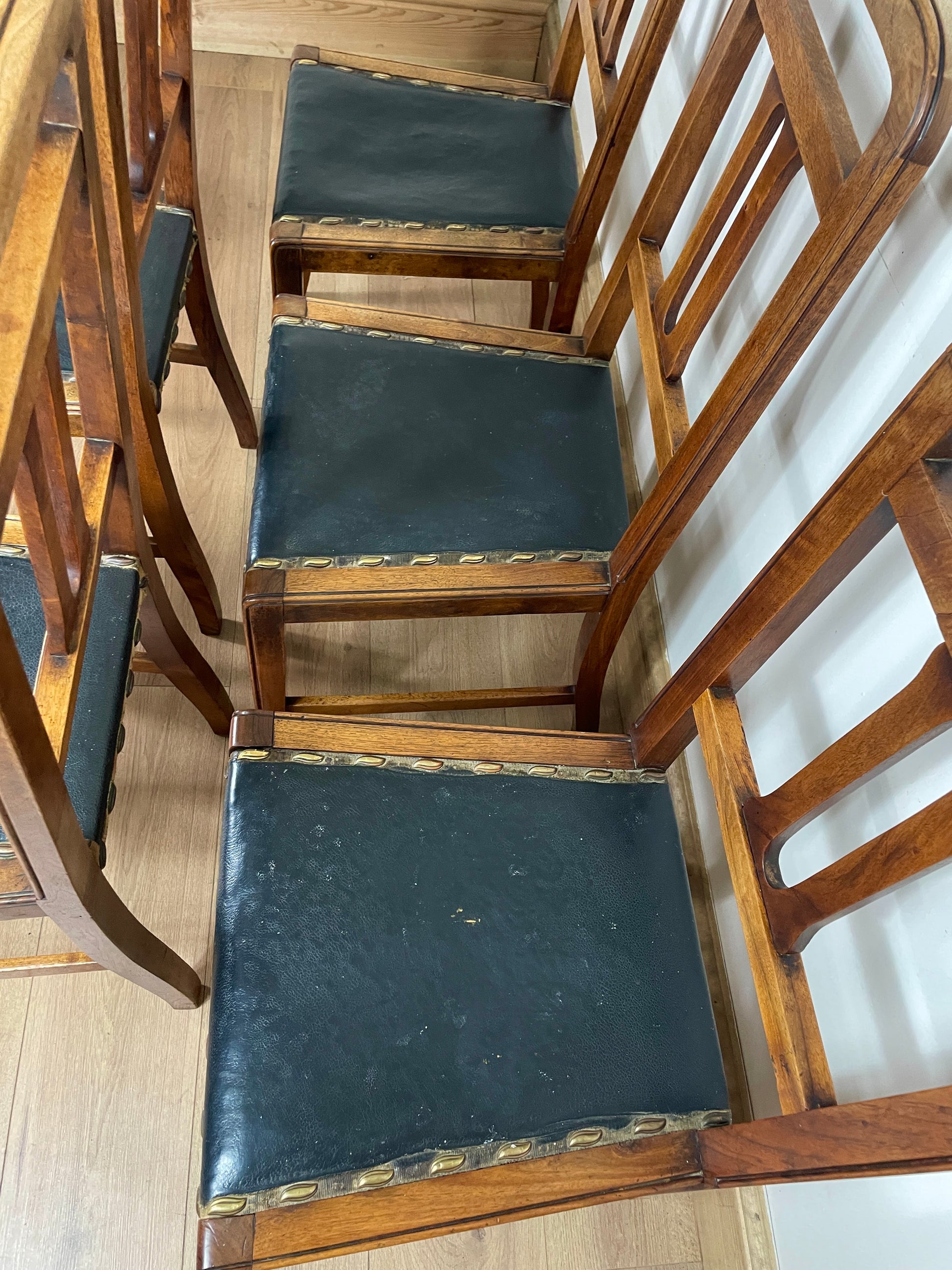 Wooden chairs with black seats on a wooden floor