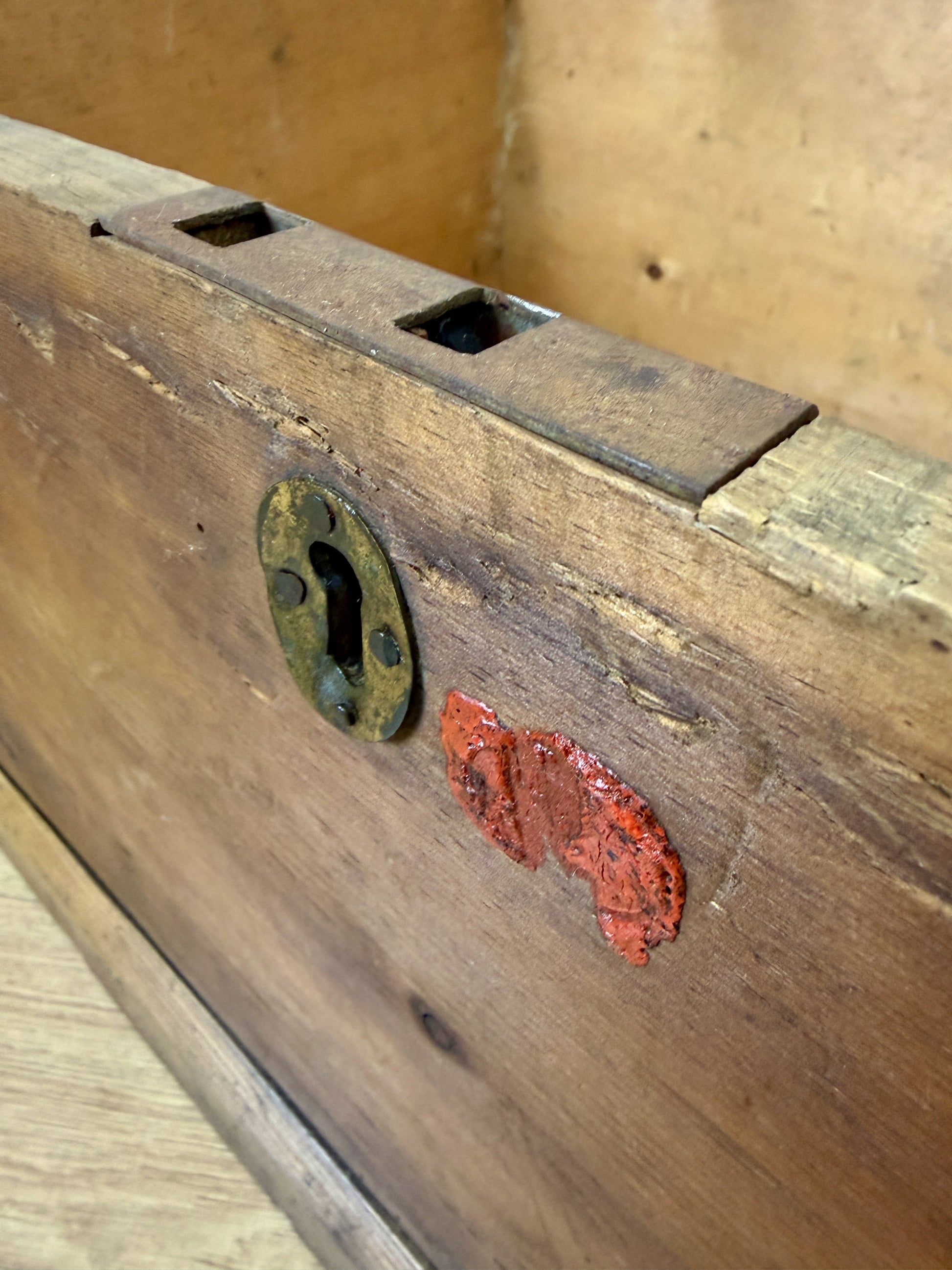 Close-up of an old wooden lock with a metal keyhole on a wooden surface.
