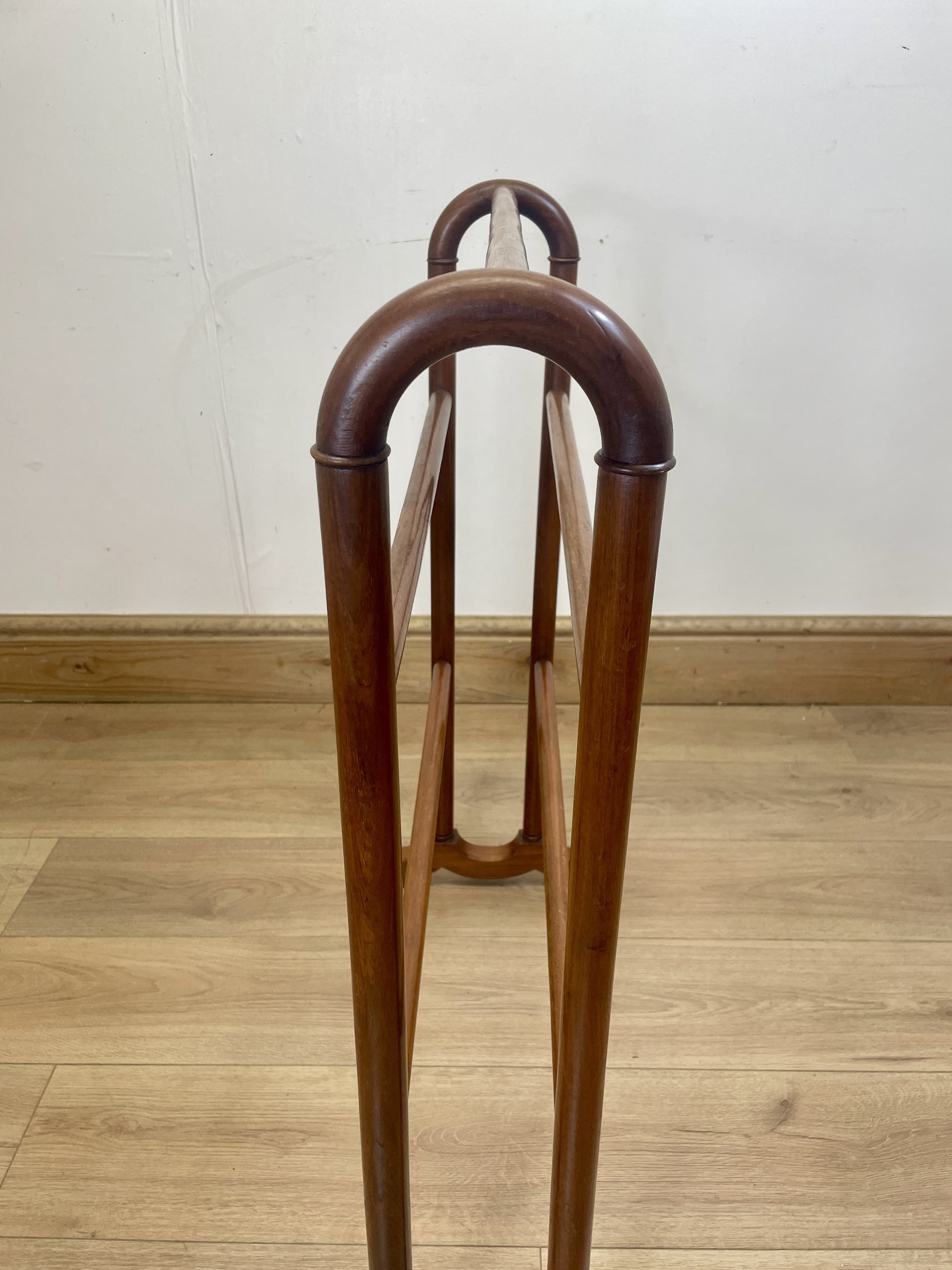 Wooden chair with curved backrest on a wooden floor against a white wall