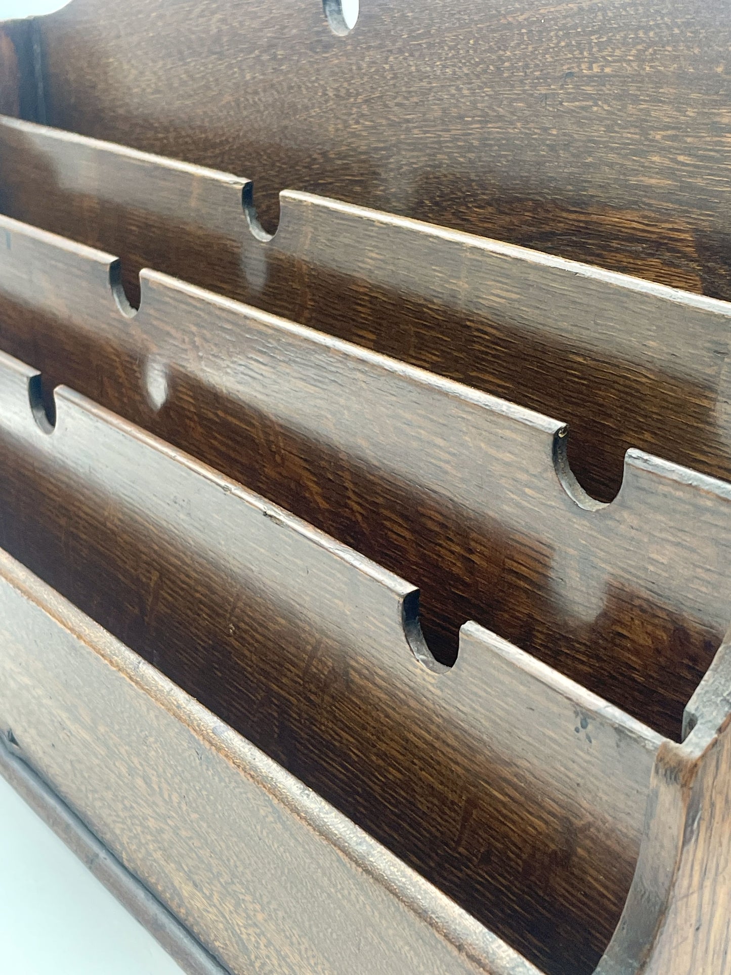 Wooden cutting board with slotted design on a white surface