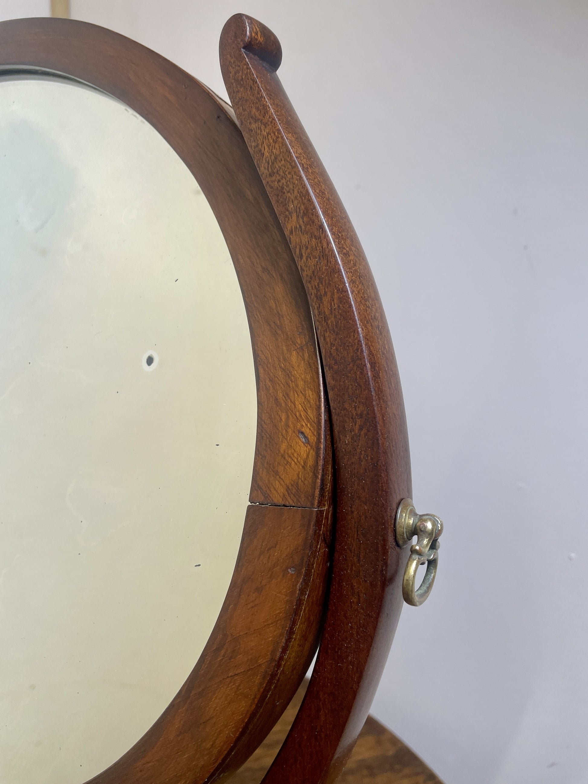 Wooden circular object with a handle on a white background