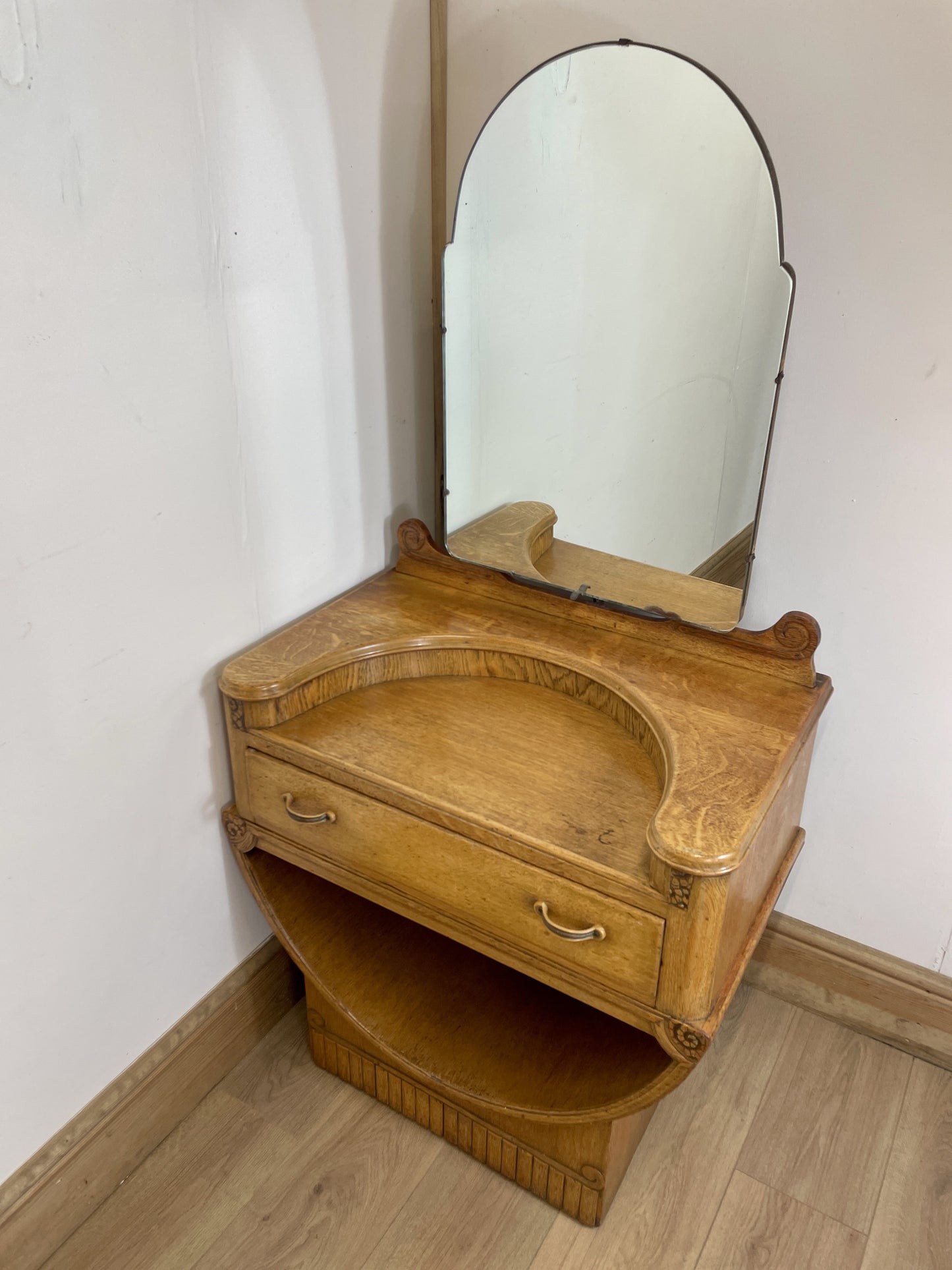 Wooden vanity with mirror on a white wall