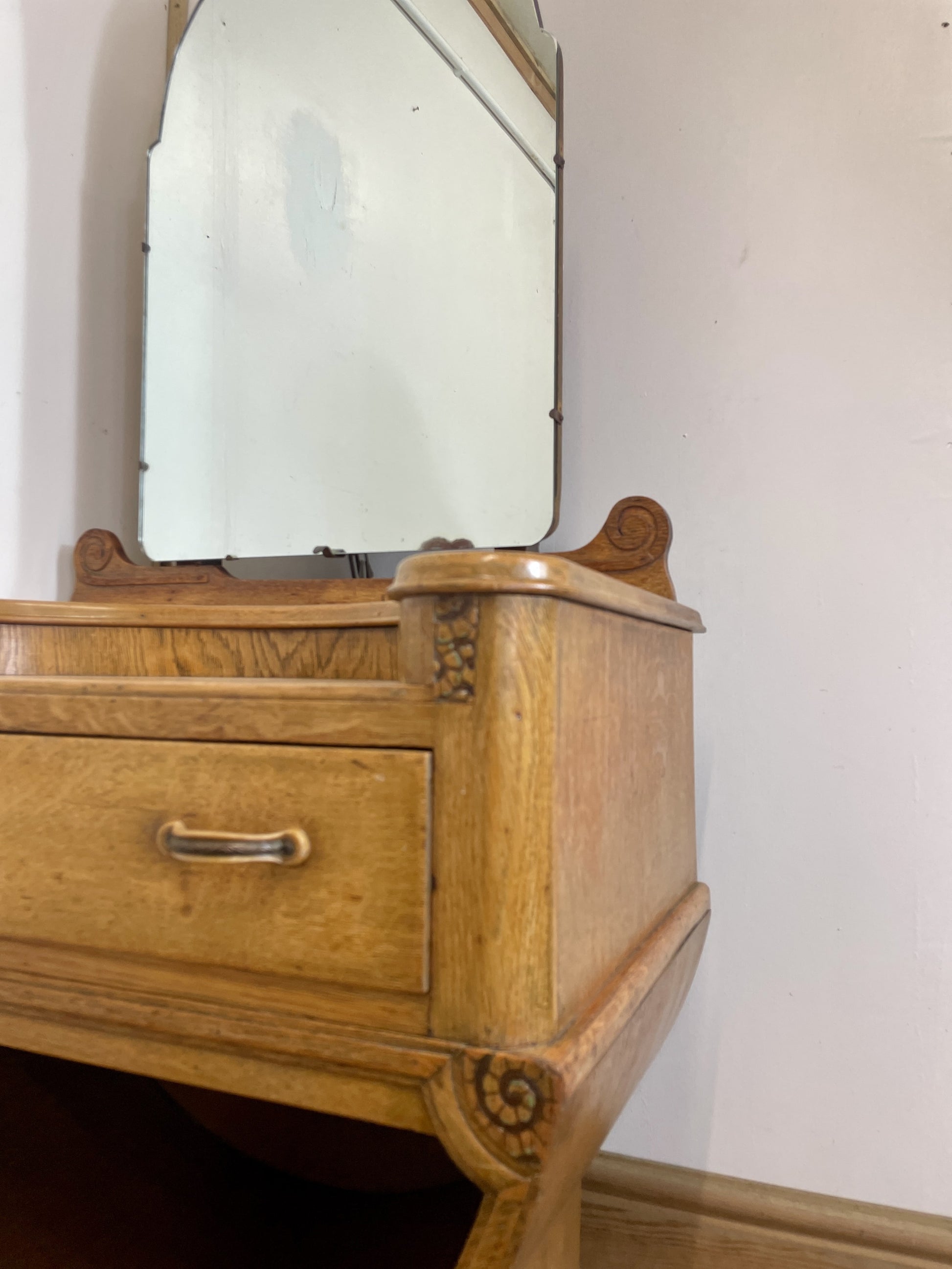 Wooden dresser with a mirror on a white wall