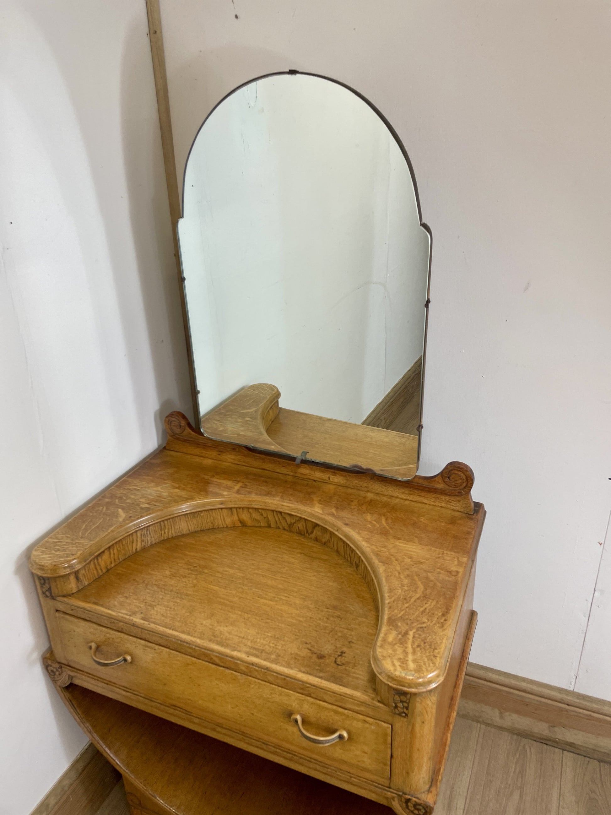Wooden vanity with mirror against a white wall