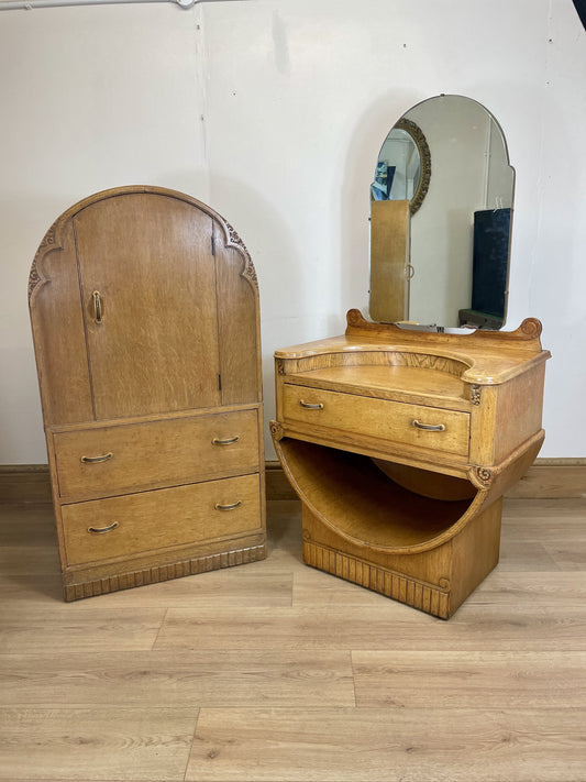 Wooden armoire and vanity with mirror on a wooden floor.