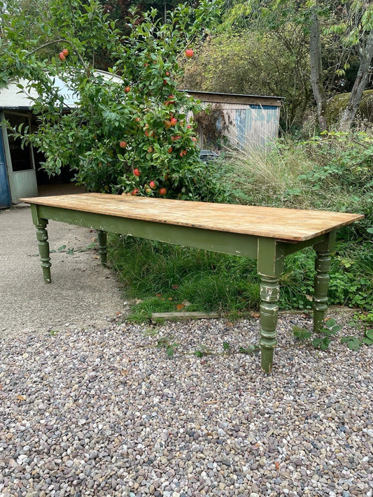 Wooden table with green legs in a garden setting