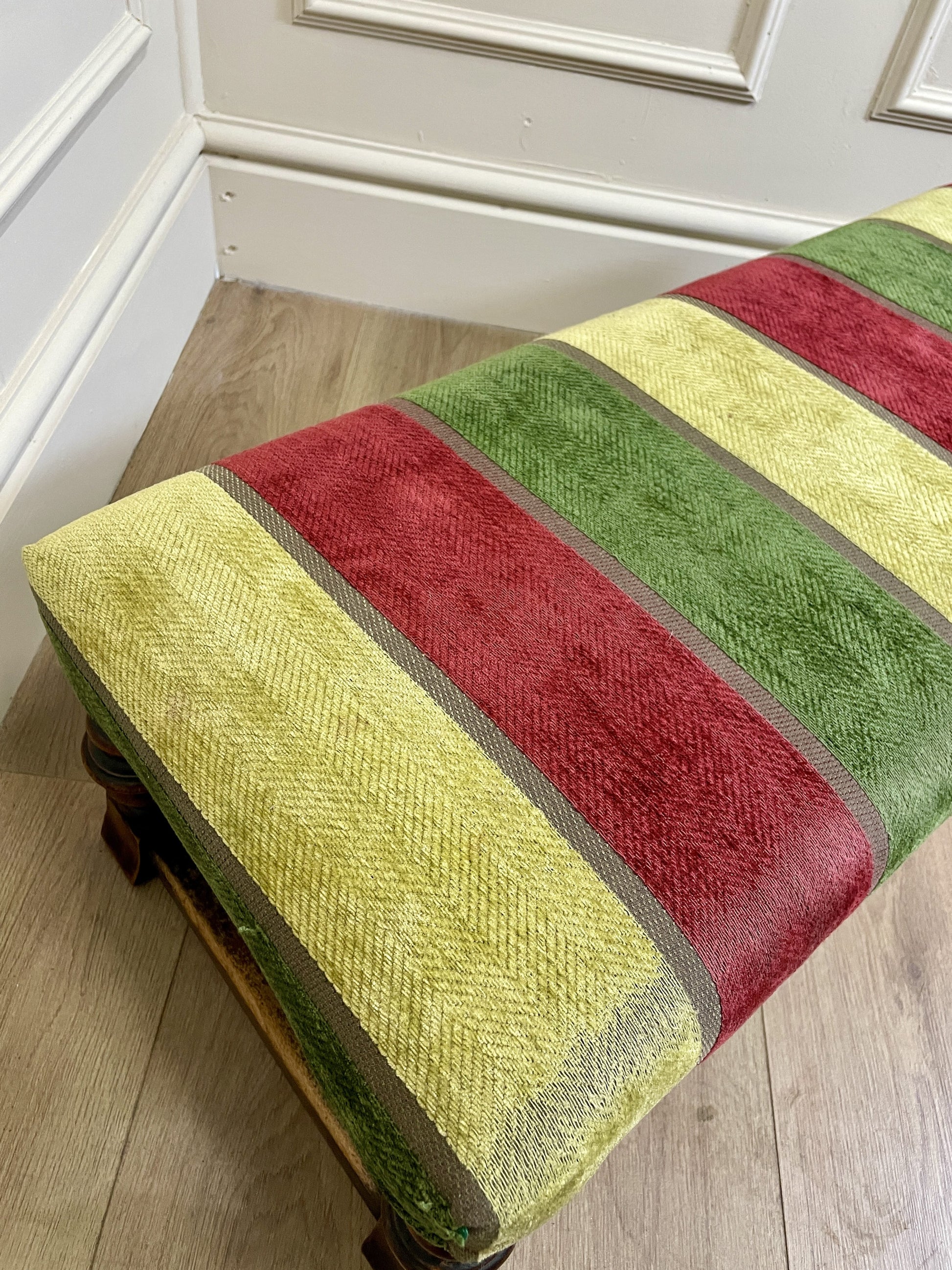 Vintage solid oak long low footstool with multicoloured upholstery and turned legs. Restored, sturdy and full of charm – a perfect accent for any living space.