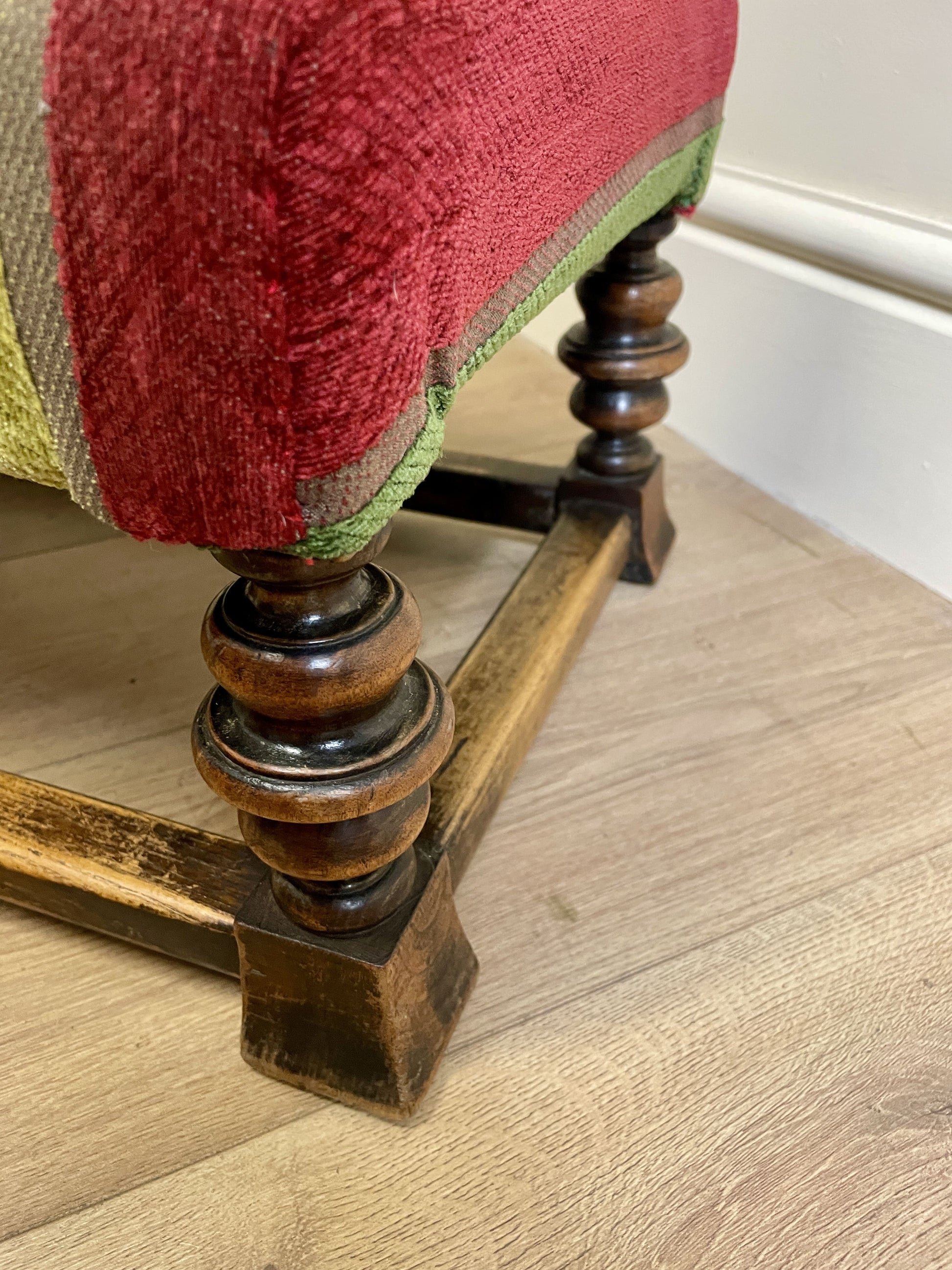 Vintage solid oak long low footstool with multicoloured upholstery and turned legs. Restored, sturdy and full of charm – a perfect accent for any living space.