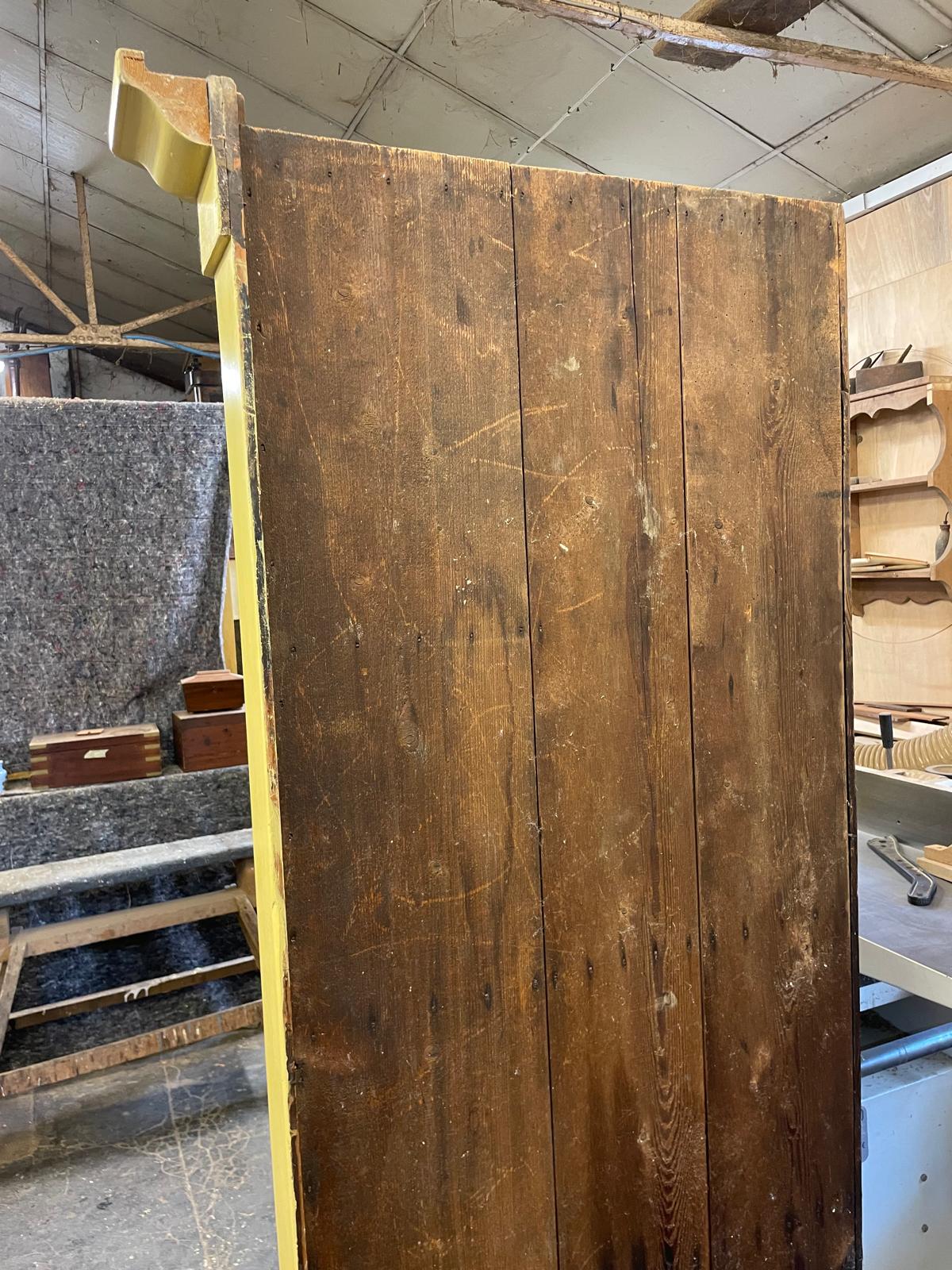 Large wooden panel with visible wear in an indoor setting