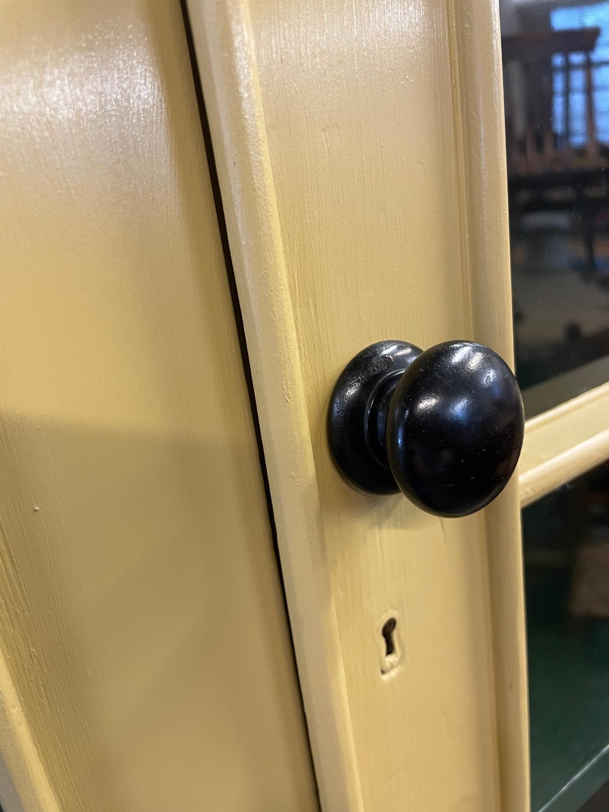 Close-up of a black door handle on a beige door