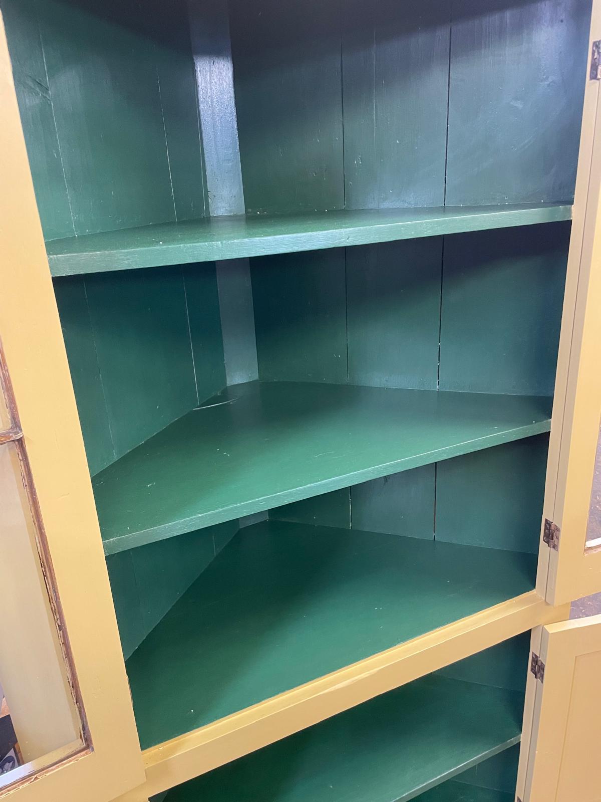 Green cabinet with yellow frame and glass doors